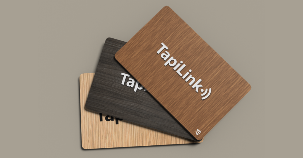 Three different designs of TapiLink NFC business cards featuring wood textures in light, dark, and medium tones.