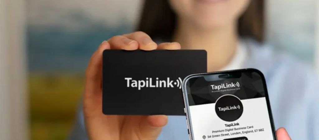 Person holding a TapiLink NFC business card with a phone showing their digital contact profile for efficient networking.